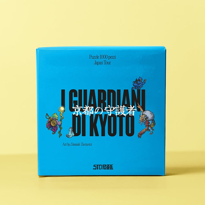 A blue StoPuzzle box with "I Guardiani Di Kyoto" and Japanese text, featuring Daniele Turturici's cartoon characters, contains a 1,000-piece jigsaw puzzle.